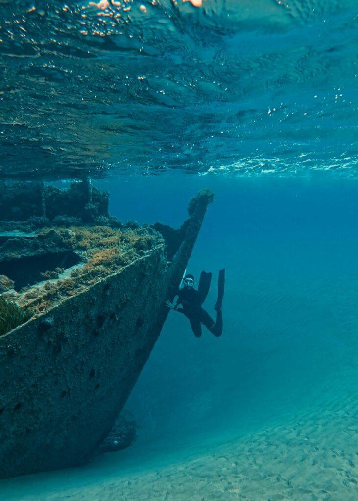Scuba diver exploring a shallow historic shipwreck in the Ionian Sea, Greece.