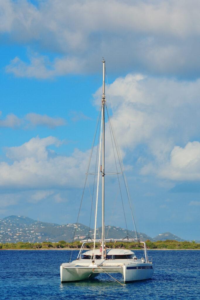 Modern sailing catamaran anchored in a turquoise bay for bareboat charter greece