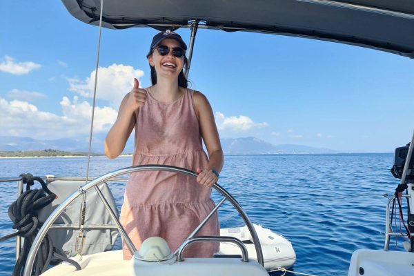 A happy passenger enjoying a luxury sailing holiday in the Ionian with a private skipper, 2026 season